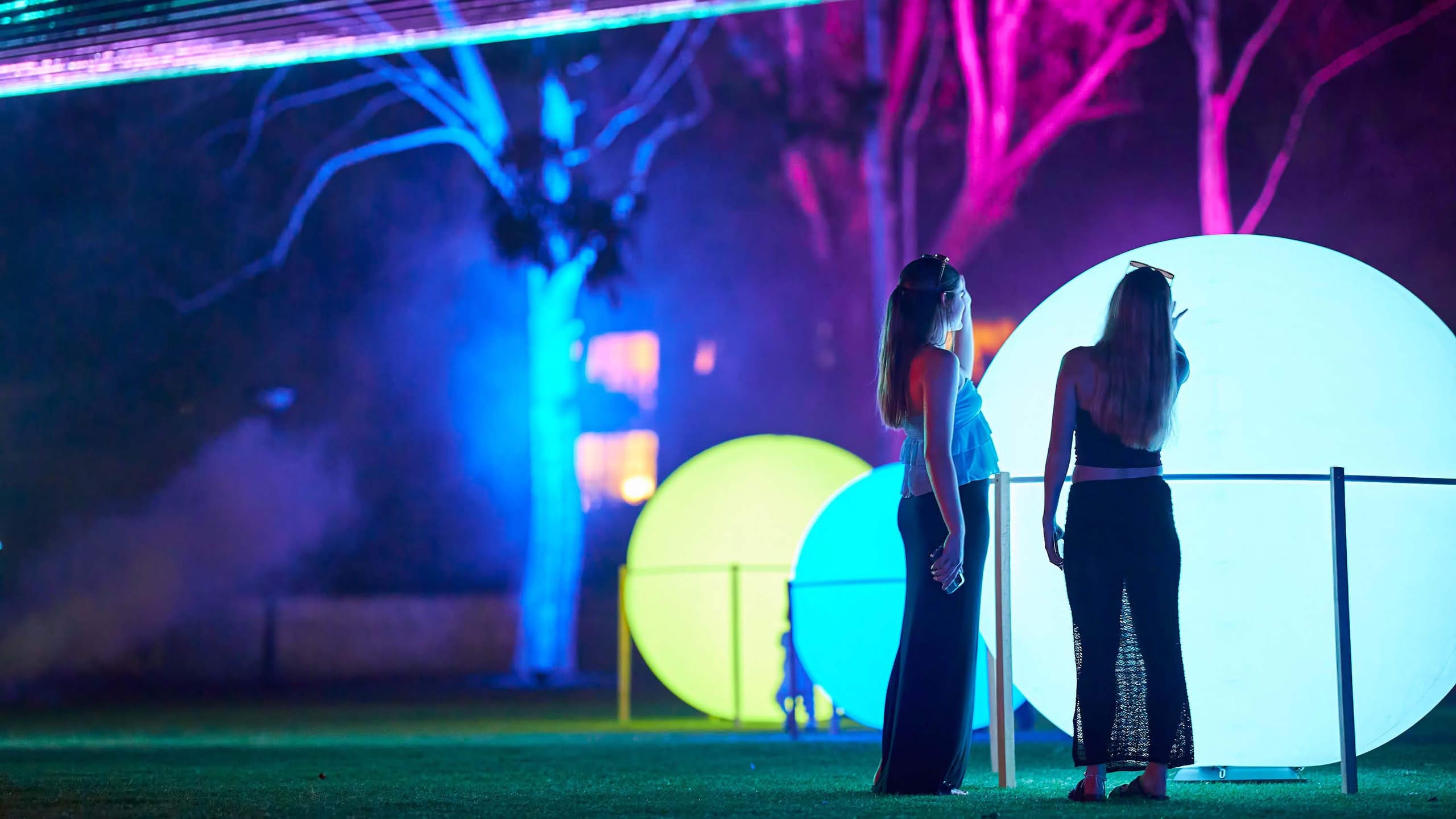 Blue illuminated arches reflected on the lawn